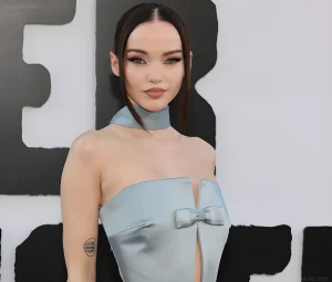Dove Cameron позирует на красной дорожке в голубом платье без бретелек, демонстрируя татуировку на предплечье
