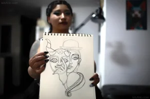 Daniela Artemisa holding a sketch of a face with traditional elements
