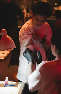 Тату-мастер делает татуировку клиенту во время мероприятия CENSU Crew Tattoo Pop-Up в Golden Gip.