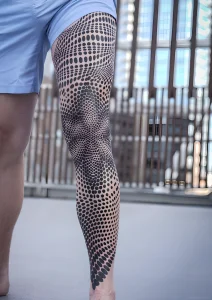 Геометрическая татуировка на ноге от Corey Divine, выполненная в технике дотворк и Blackwork.