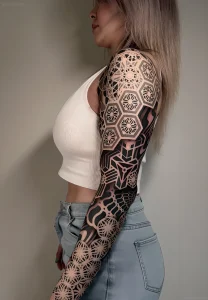 Геометрическая татуировка на руке и плече в стиле Blackwork от Corey Divine. Сложный орнамент, мандала, сакральная геометрия.
