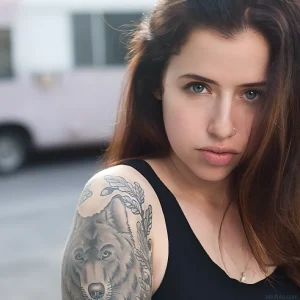 Фотография Sash Suicide с татуировкой волка на плече, крупный план лица и тату.