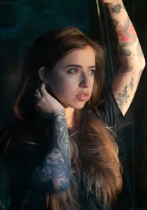 Фотография Sash Suicide с татуировками на руках и шее, демонстрирующая яркий образ и разнообразие стилей тату.