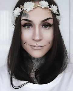 Monami Frost, тату-модель с татуировками в стиле чикано и блэкворк, крупный план лица.