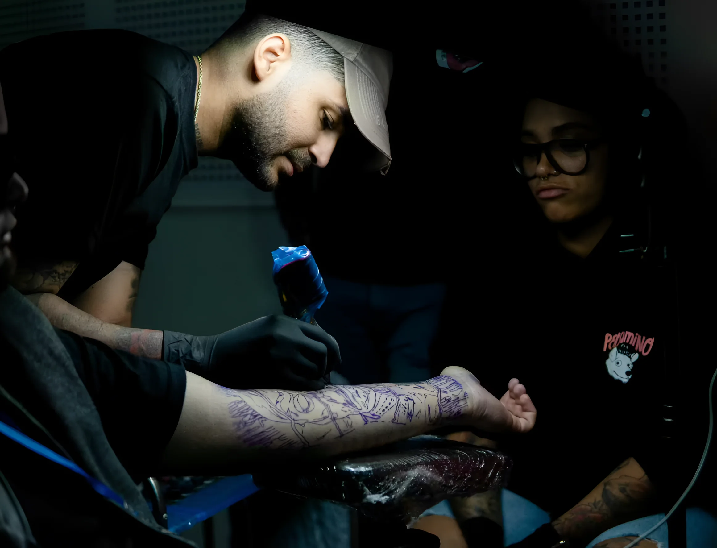 Тату-мастер делает татуировку клиенту на фестивале Villain Arts Tattoo Festival в Сан-Антонио