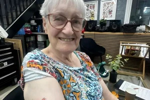 88-летняя Мерлин Блэтчфорд улыбается в тату-салоне после получения своей первой татуировки.