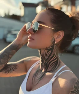 Модель joii_xoxo в солнечных очках с выразительными татуировками на шее и руке