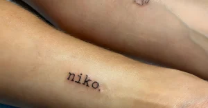 Крупный план татуировки 'niko.' на запястье Мэри Фитцджеральд