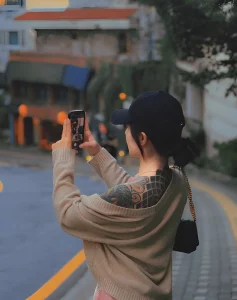 Тату-модель Janejaneey фотографирует на телефон, демонстрируя татуировки на плече и спине.