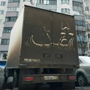 Фотография татуировки на задней части грузовика: череп быка, меч и надпись 'PROBOYNICK'.