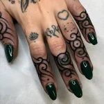 Черно-белая татуировка на пальцах в стиле Blackwork, изображающая спиральные узоры, обвивающие фаланги. Фото для вдохновения тату на пальцах.