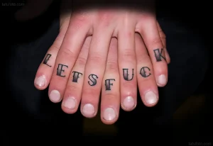 Фото татуировки на пальцах: черная надпись 'LETS FUCK' на фалангах пальцев, вид сверху, темный фон.