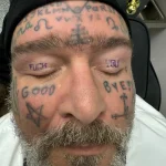 Фото татуировки на веках мужчины с надписями 'FUCK', 'GOOD', 'BYE' и 'YOU', а также символами и буквами на лбу.