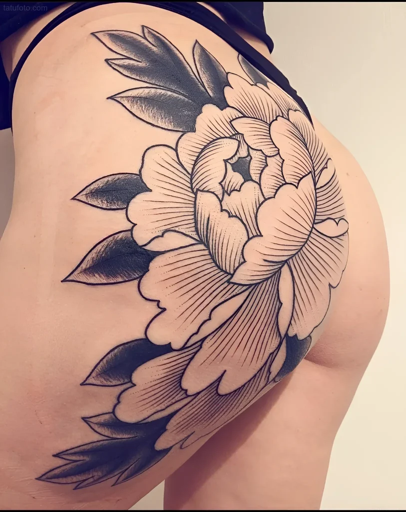 Black and grey tattoo of a peony on the buttock, done in a graphic style using thin lines and smooth shadow transitions.