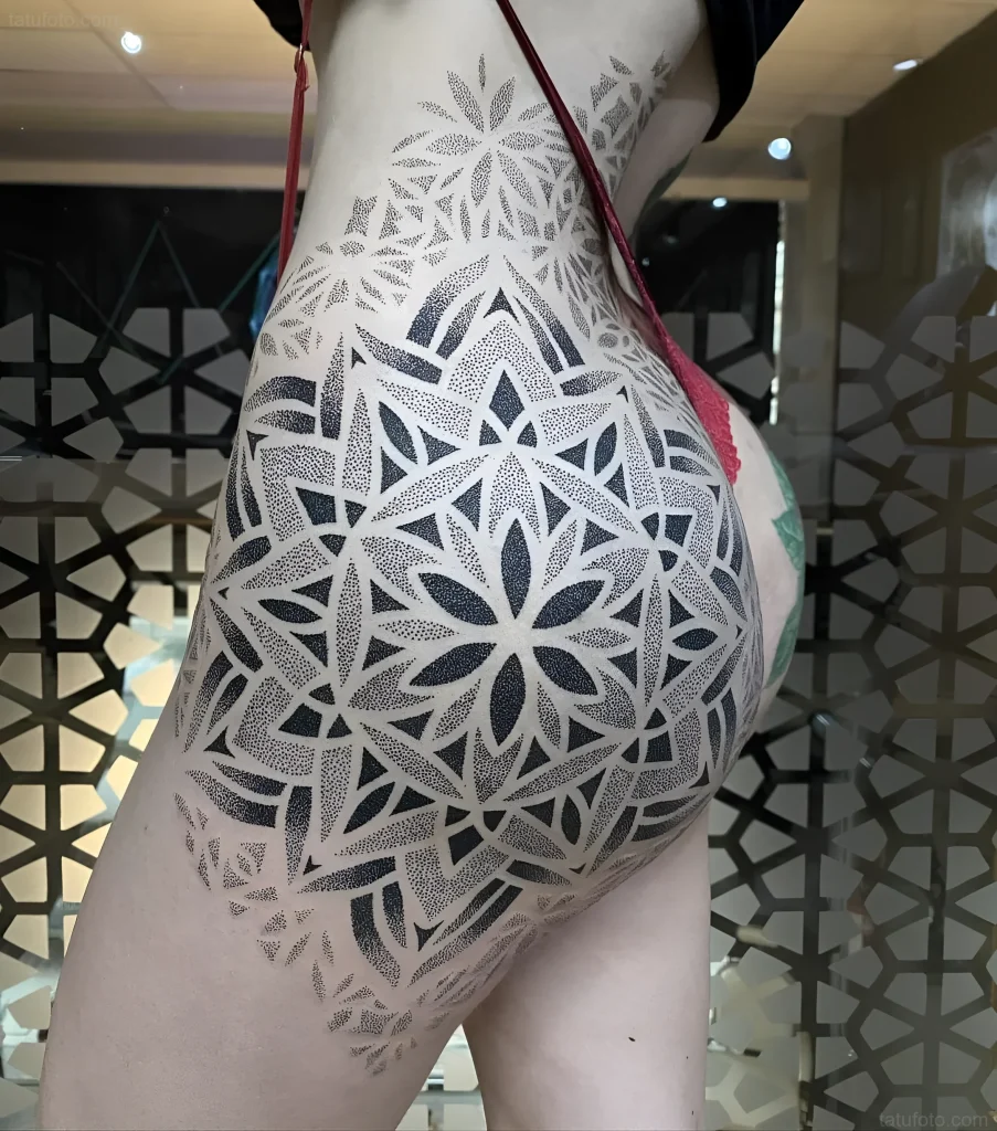 Photo of a buttock tattoo: a large Flower of Life pattern, done in dotwork style, on a woman's body.