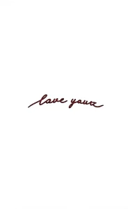 Минималистичная татуировка надписью 'love yours' на ягодице, выполненная тонкой линией, шрифт каллиграфический, цвет – темно-красный.