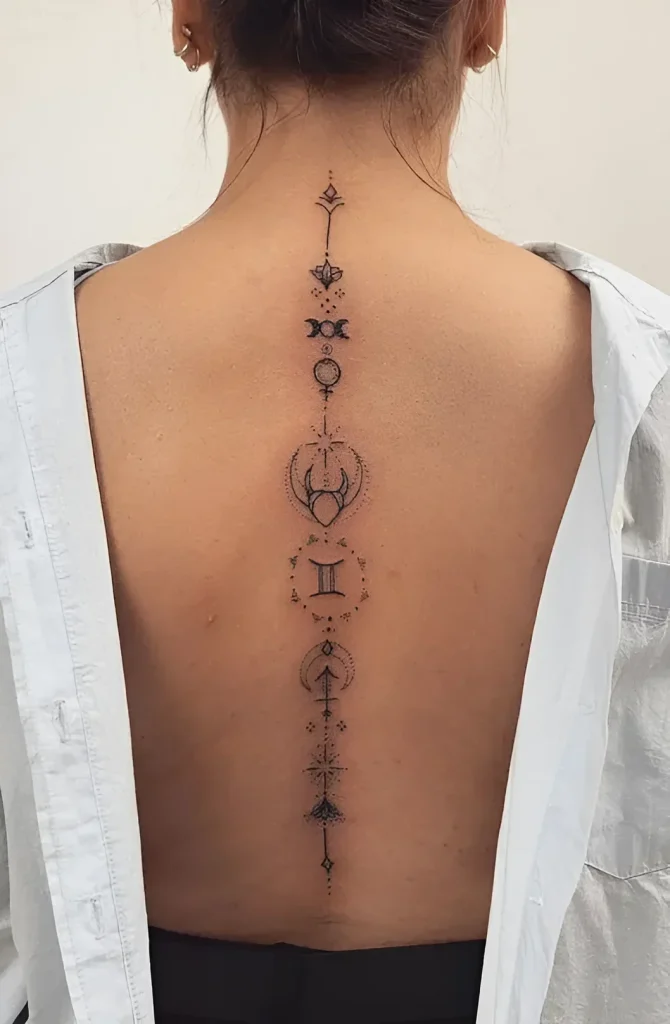 Tattoo photo along the spine: a thin line with astrological symbols, a moon, and the Gemini zodiac sign, done in dotwork technique.