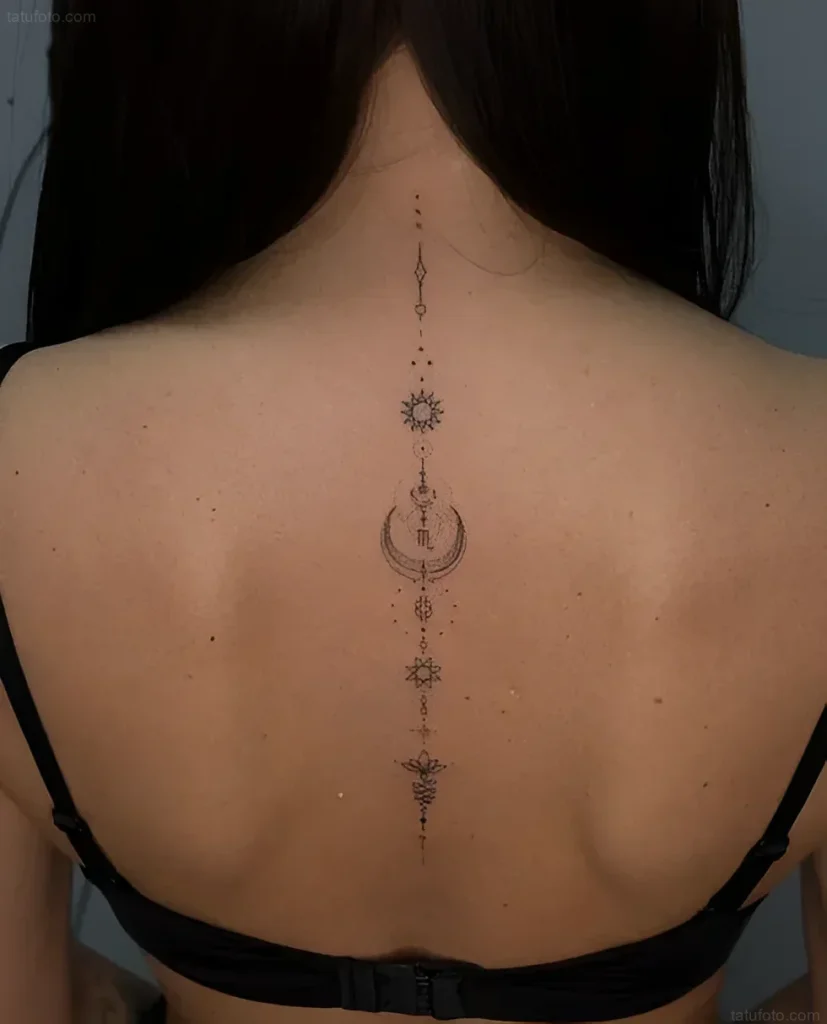 Tattoo photo along the spine: Sun, moon, stars, and lotus in minimalist style