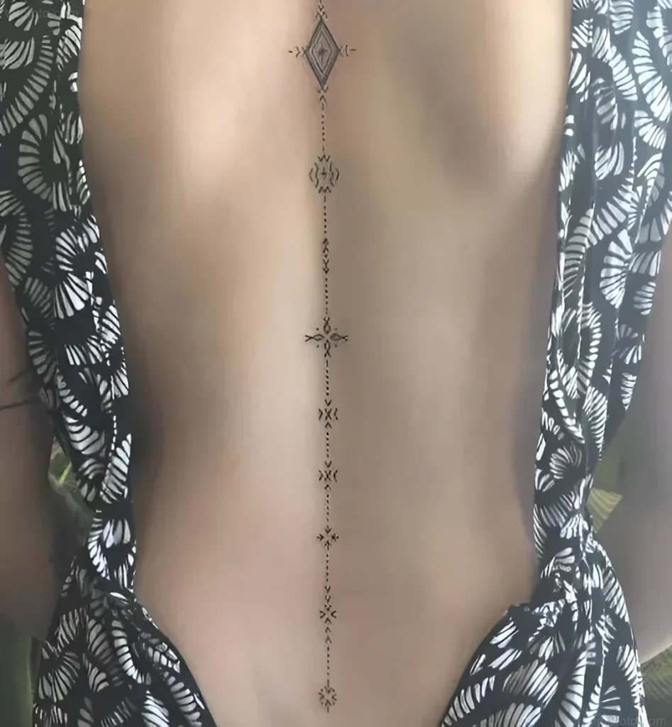 Tattoo photo on a woman's back: a thin black line with geometric symbols, located along the spine.