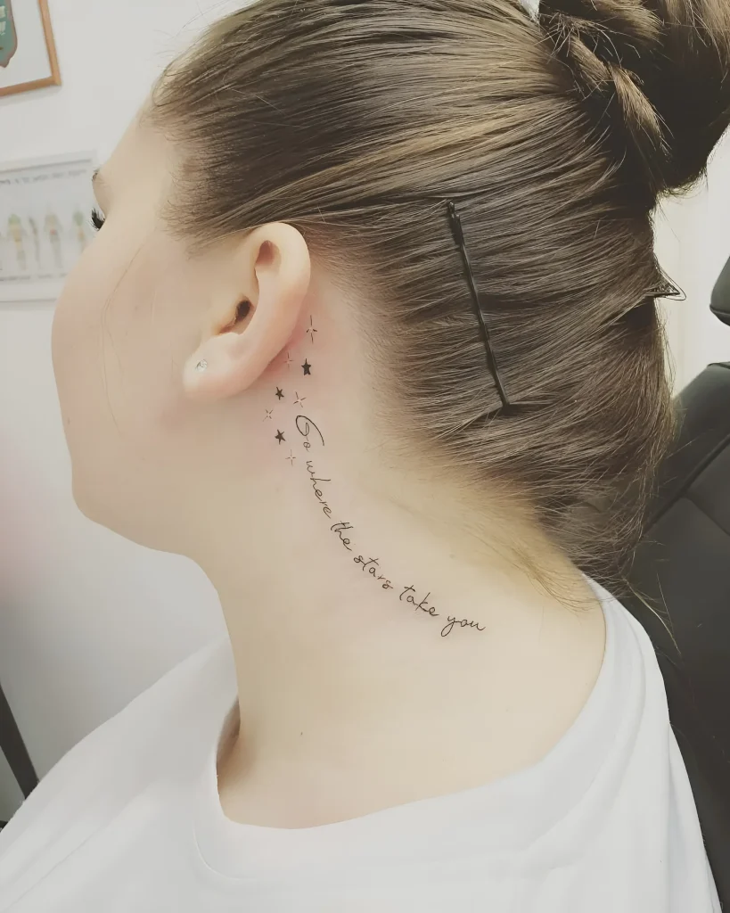 耳后纹身照片:优雅的文字'Go where the stars take you'和一串小星星,纹在女孩的脖子上.
