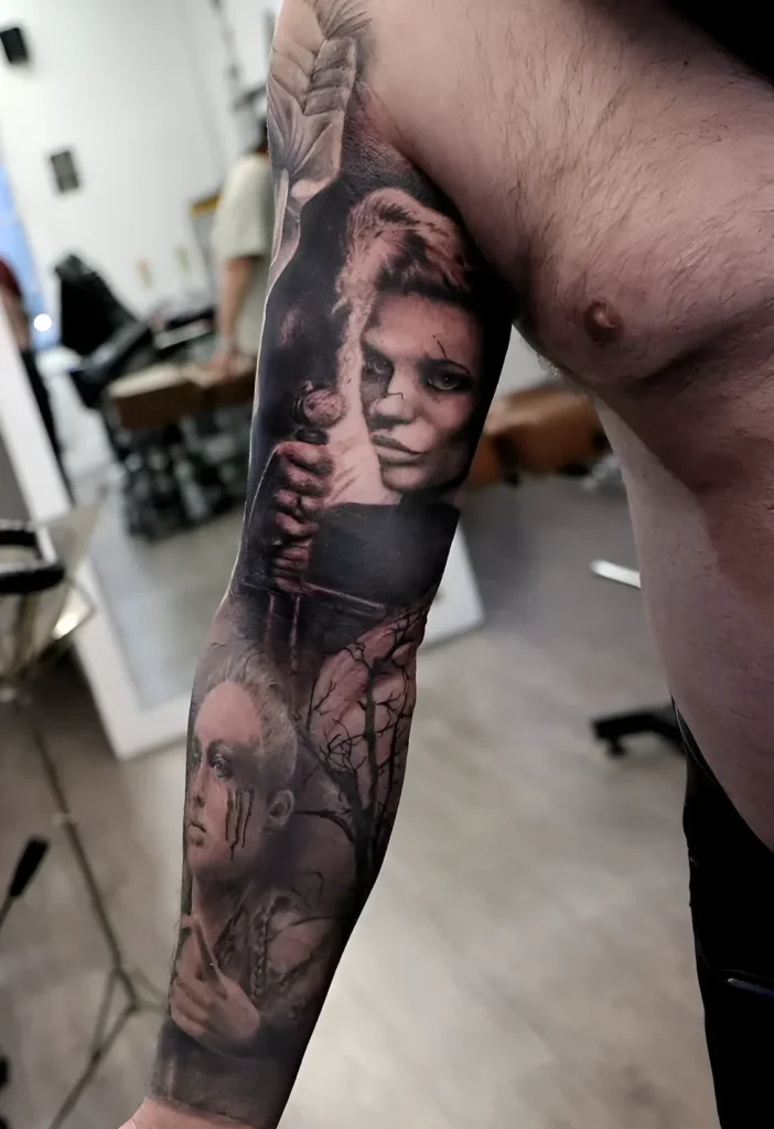Photo de tatouage sur le biceps : portrait réaliste d'une femme entrelacé avec des branches d'arbres, réalisé en tons noir et gris.