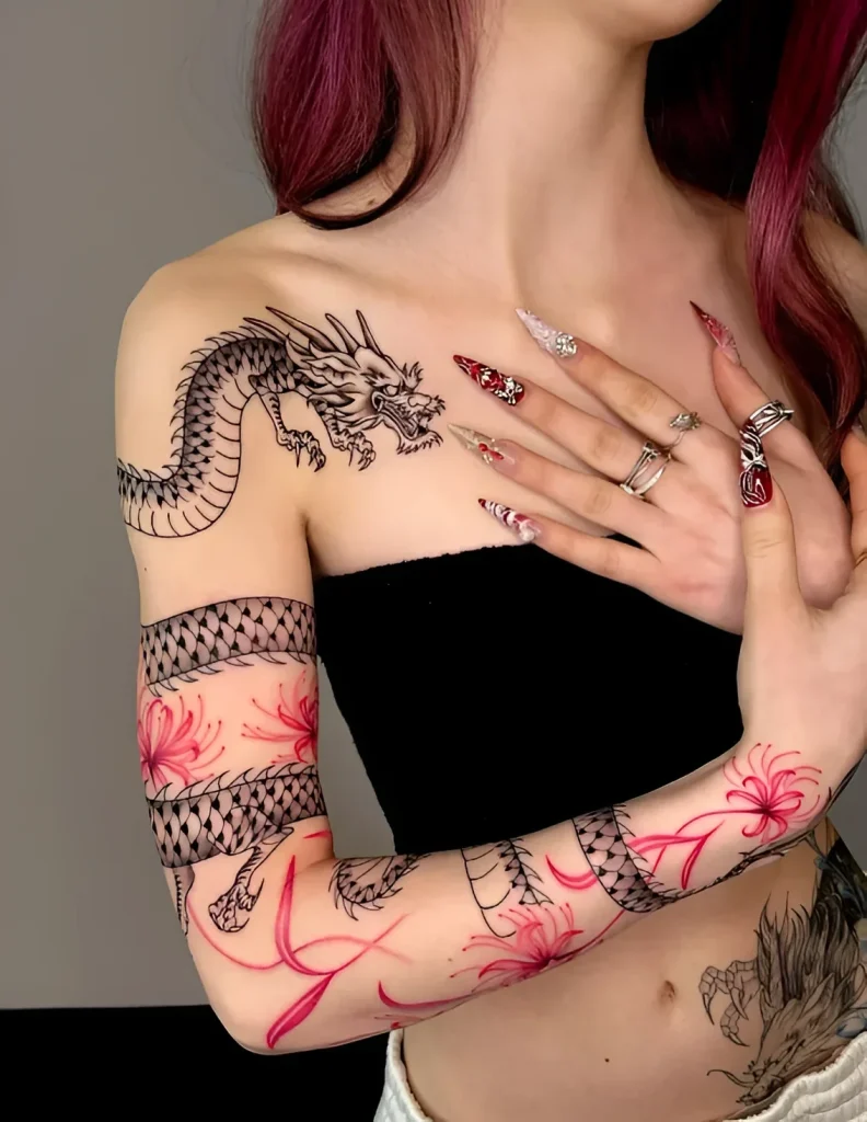 Black and white tattoo of a dragon coiling around the collarbone and extending to the shoulder, with added red azalea flowers.