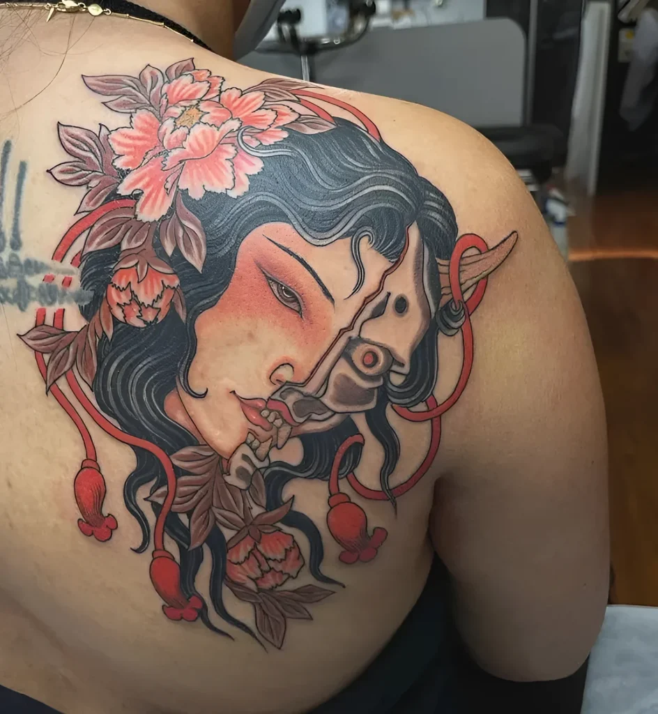 Photo of a tattoo on the shoulder blade: an image of Oni, a Japanese demon, with peony flowers, done in traditional Japanese style.