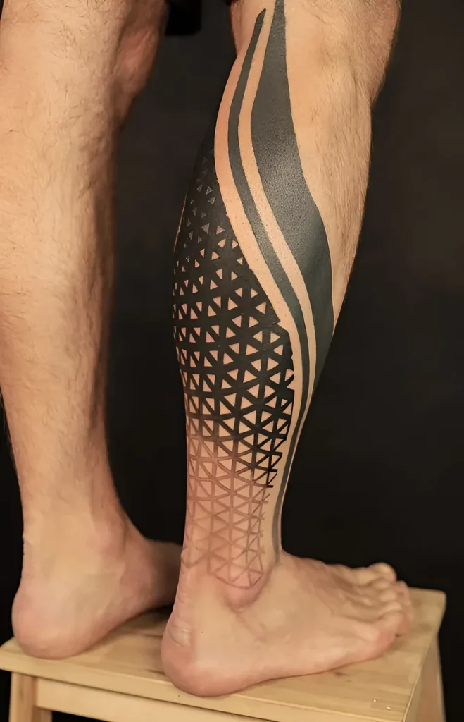 Photo of a calf tattoo: complex geometric pattern in Blackwork technique, transitioning from dense black to a gradient effect.