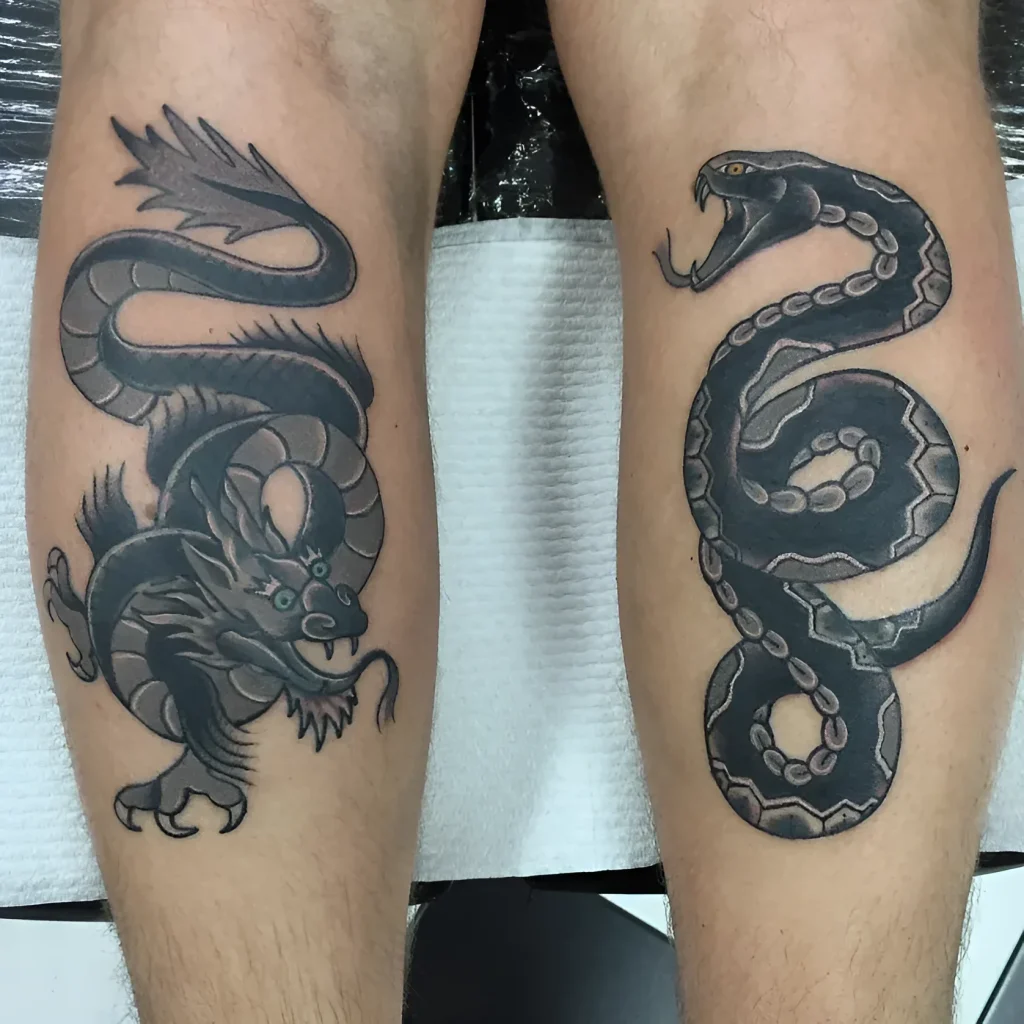 Photo of calf tattoos: realistic dragon and snake, done in blackwork technique, symbolizing yin and yang.