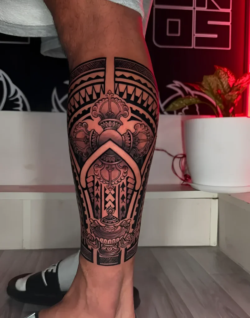 Black and white calf tattoo in Polynesian style with stylized scales and a central ornament resembling a temple.