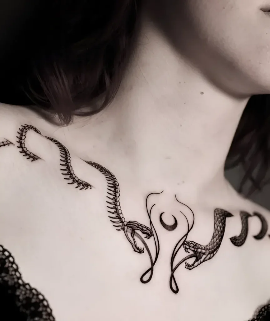 Black and white tattoo of a snake coiling around the collarbone and the moon, done in a graphic style.