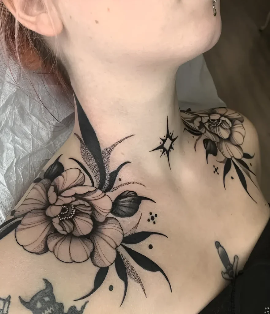 Black and white collarbone tattoo with large flowers, dots, and pointed leaves, done in a graphic style.