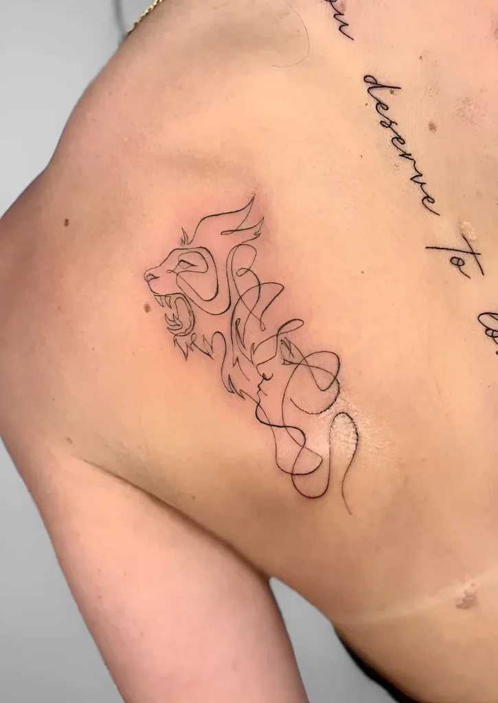 Black and white tattoo of a dragon on the shoulder blade, done in fine line technique, emphasizing the elegant curves of its body and face.