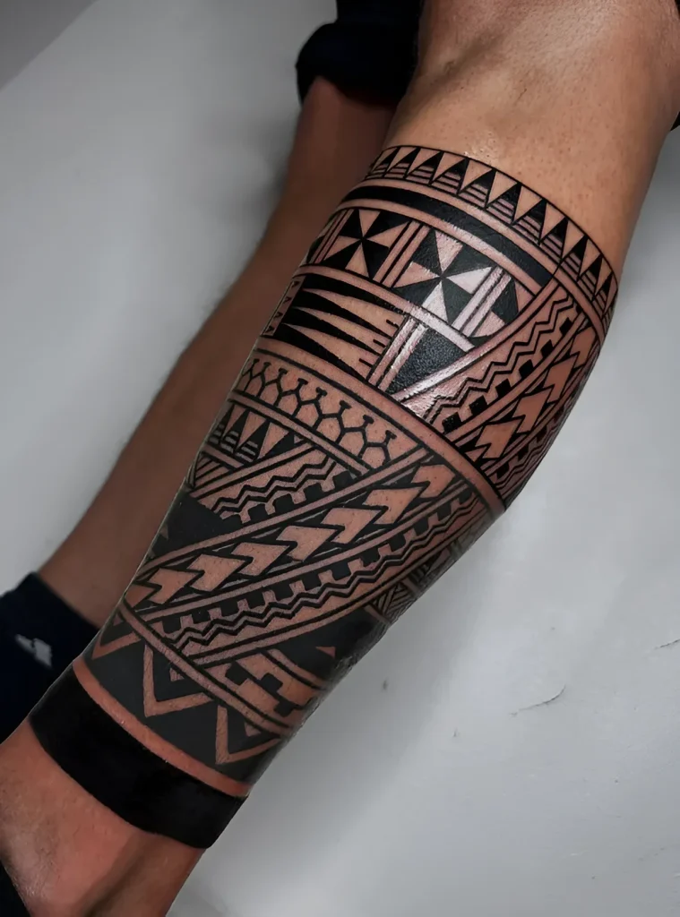 Black and white tattoo in Polynesian style on a man's calf, close-up