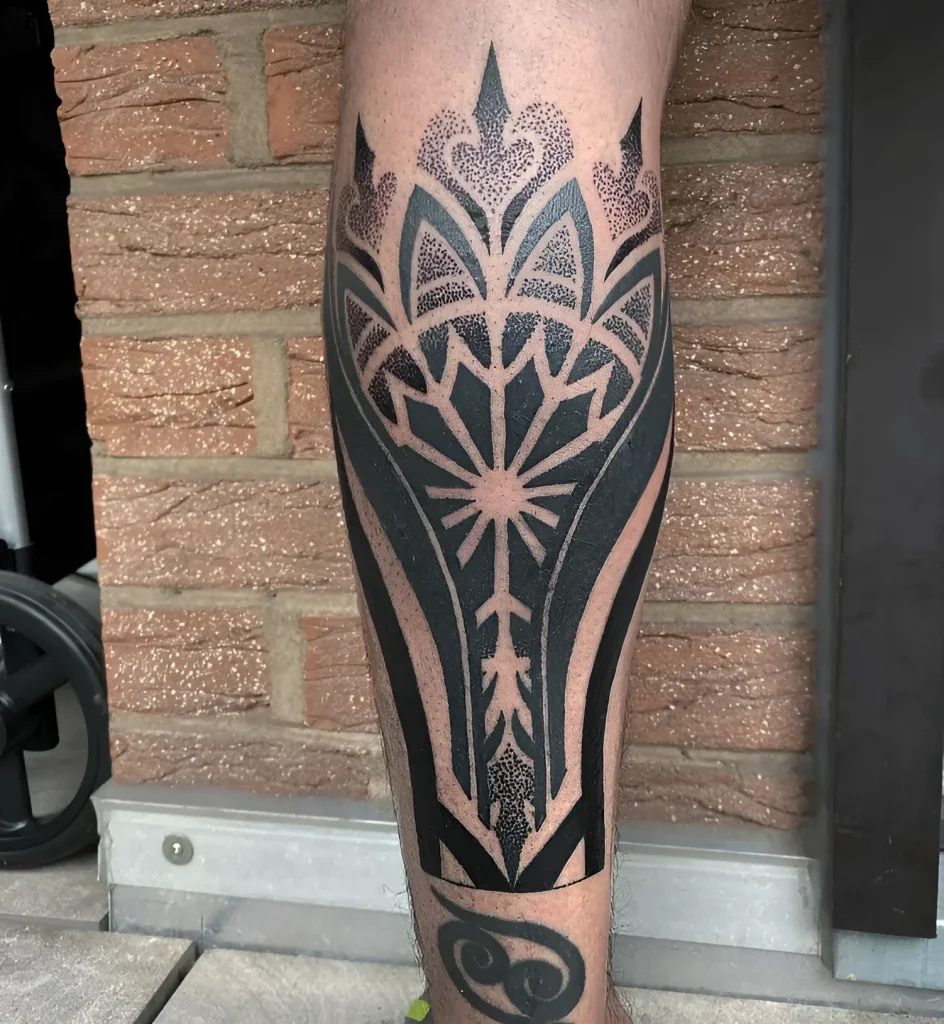 Black and white calf tattoo in geometry and dotwork style, depicting a stylized flower of life with sharp petals and dot fill.