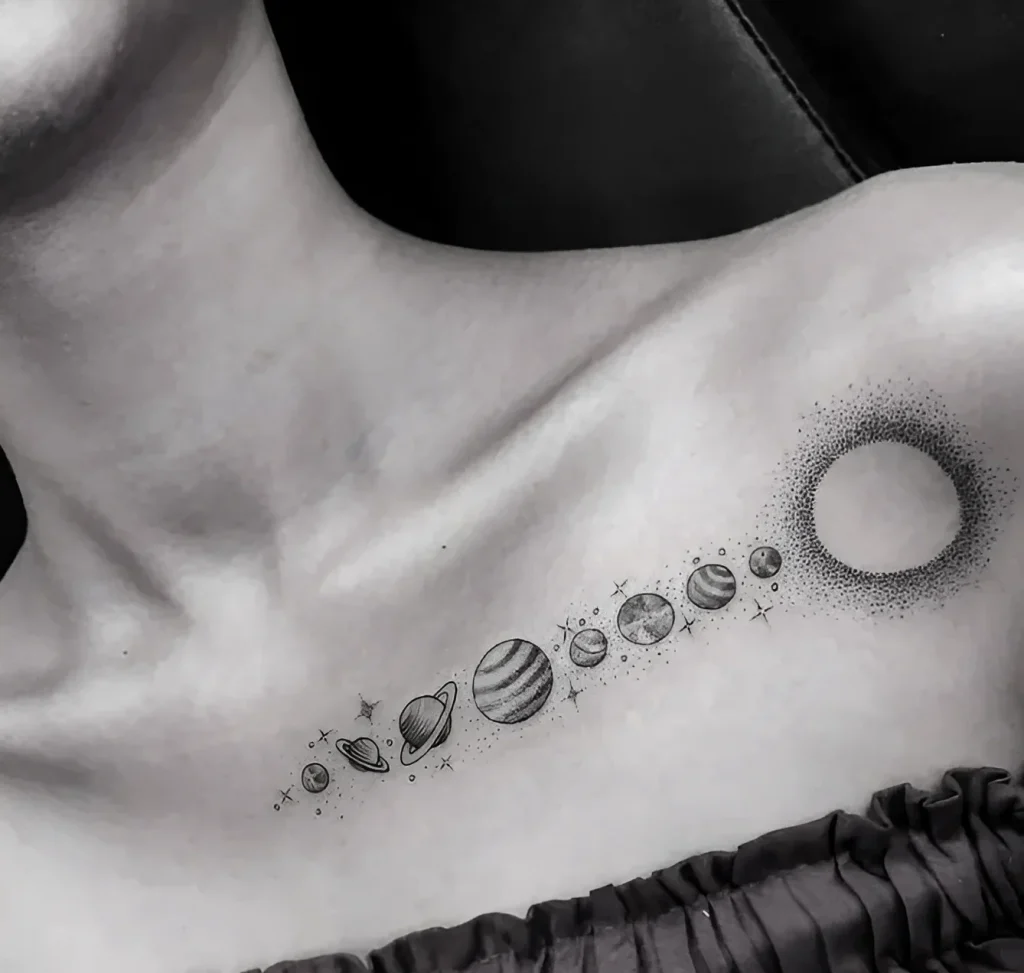 Black and white collarbone tattoo depicting planets of the Solar System and an eclipse, done in dotwork technique.