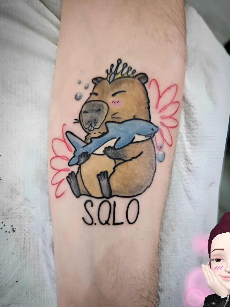 Tatouage de capybara embrassant un requin, style old school avec l'inscription 'S.QLO' sur le bras.