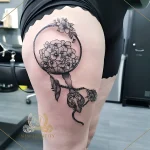 Черно-белая татуировка лупы с букетом пионов на бедрах, выполненная в графическом стиле.