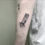 Минималистичная татуировка прищепки на руке, выполненная в технике blackwork.