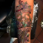 Татуировка расчески с надписью 'Live Your Purpose, Leave Your Legacy' в стиле олд скул на руке