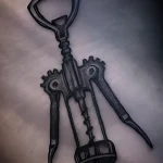 Черно-серая татуировка штопора с детальной проработкой механизма на плече