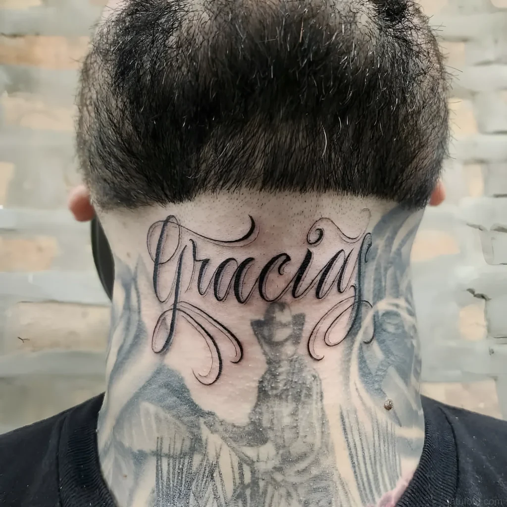 Фото татуировки надписи “Gracia” на затылке, выполненной в черном цвете, с плавными линиями и каллиграфическим шрифтом.