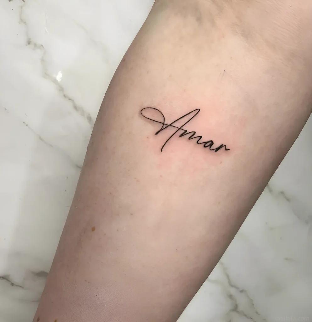 Минималистичная татуировка надпись 'Amar' на внутренней стороне запястья, выполненная тонкой линией.