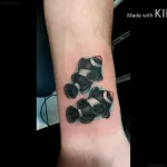 Фотография татуировки с изображением двух рыбок Клоун в реалистичном стиле на внутренней стороне предплечья.