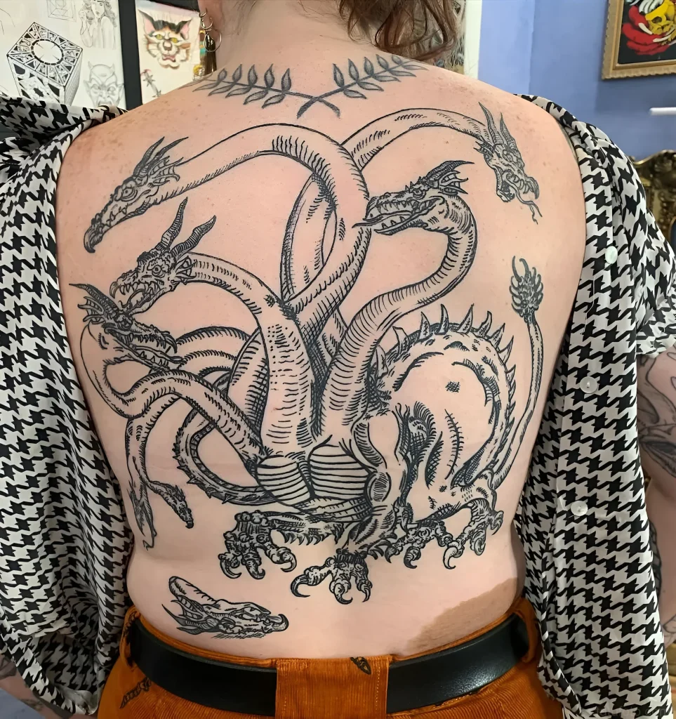 Outline tattoo of a multi-headed Hydra on the back in engraving style
