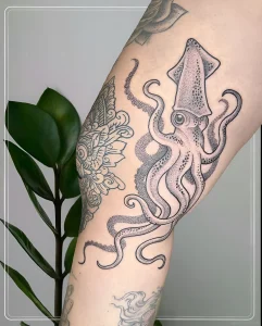 Черно-белая татуировка кальмара, выполненная в технике dotwork на колене, с детализированными щупальцами и точками, создающими эффект объема.