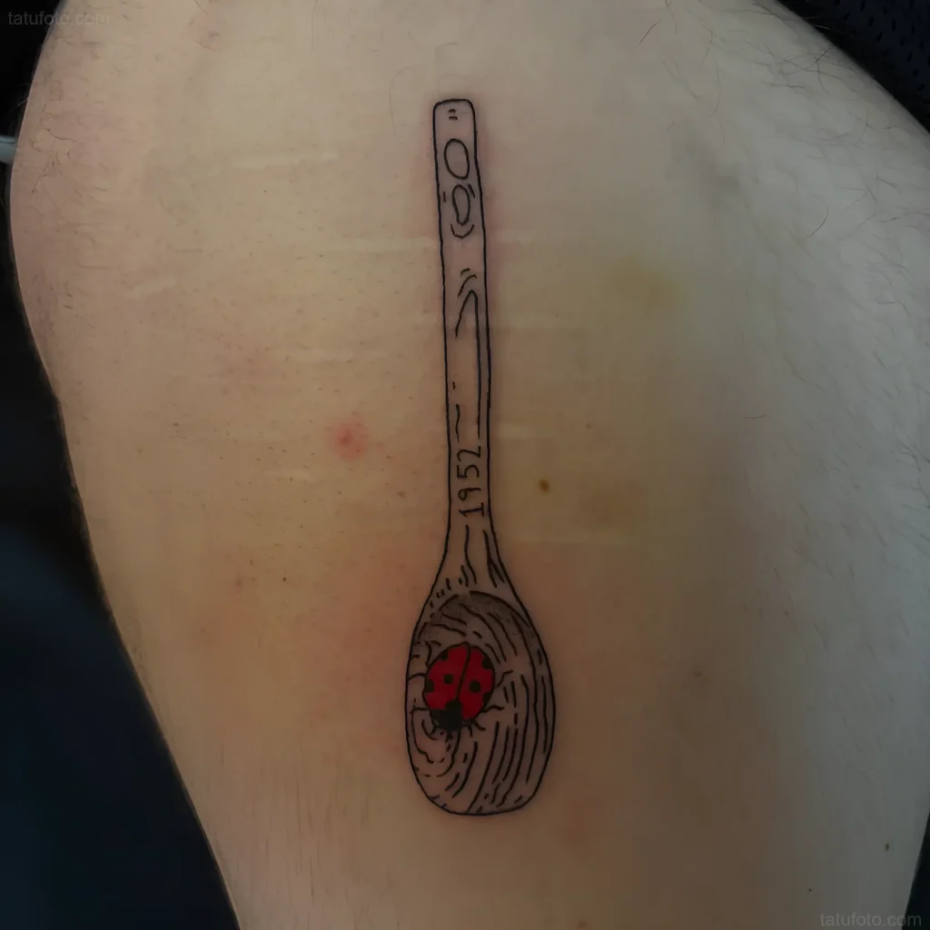 Schwarz-weißes Löffel-Tattoo mit Marienkäfer am Griff, im Grafikstil.