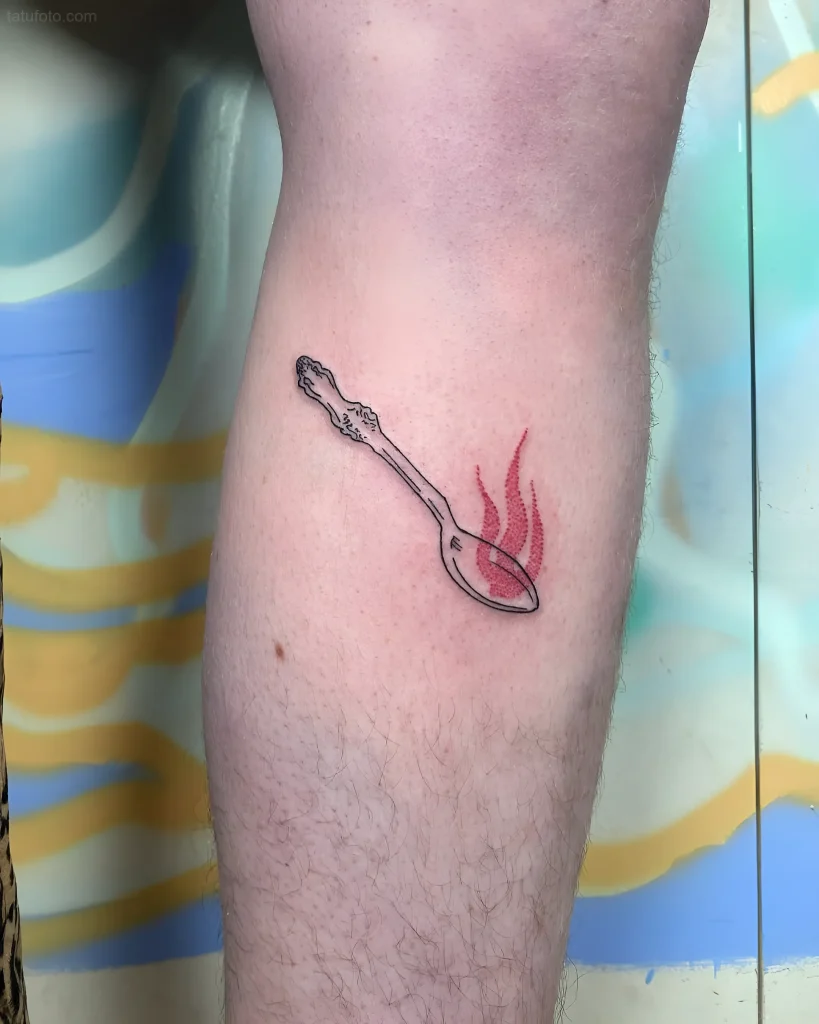 Minimalistisches Löffel-Tattoo mit Flammen am Unterschenkel, im Feinlinienstil.