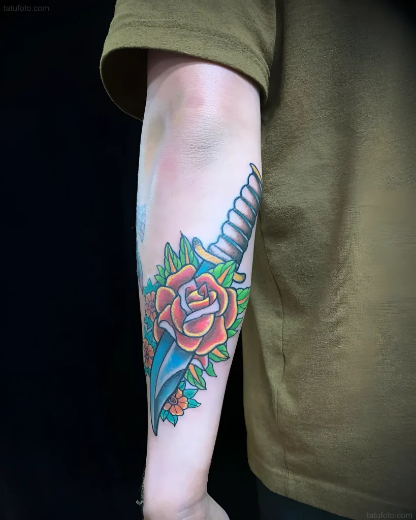 Tatouage de baïonnette avec rose sur l'avant-bras, réalisé dans le style old school