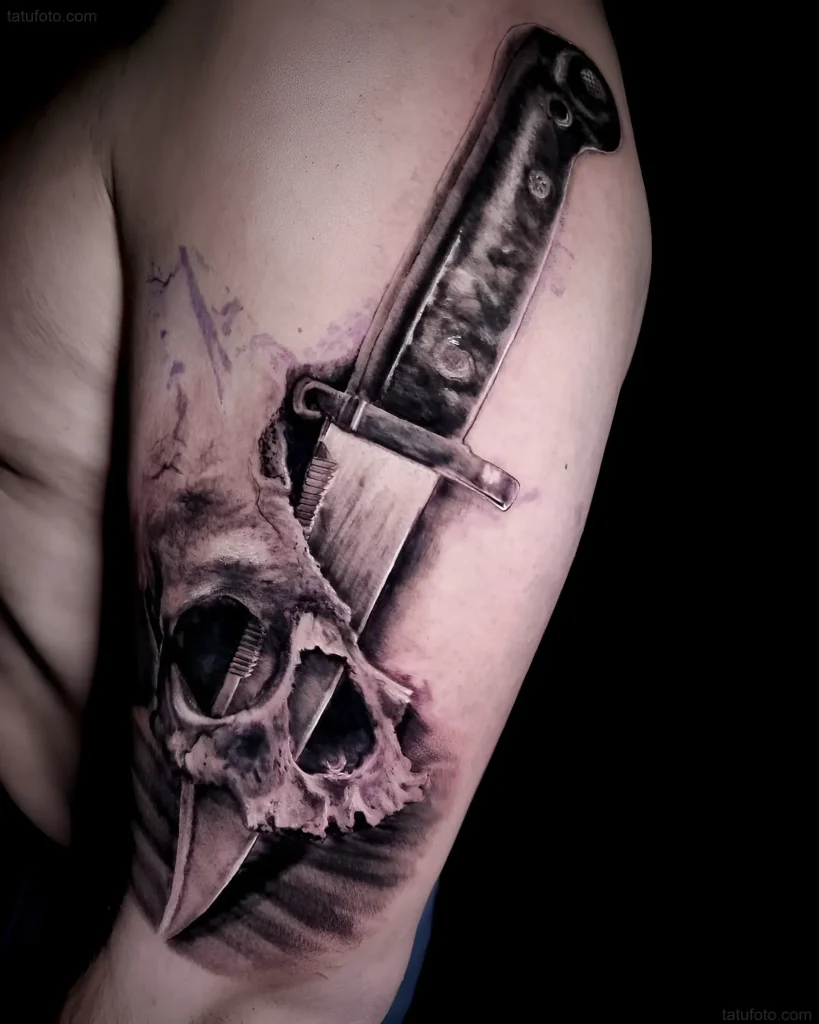 Tatouage réaliste de baïonnette transperçant un crâne, réalisé dans des tons noirs et gris.